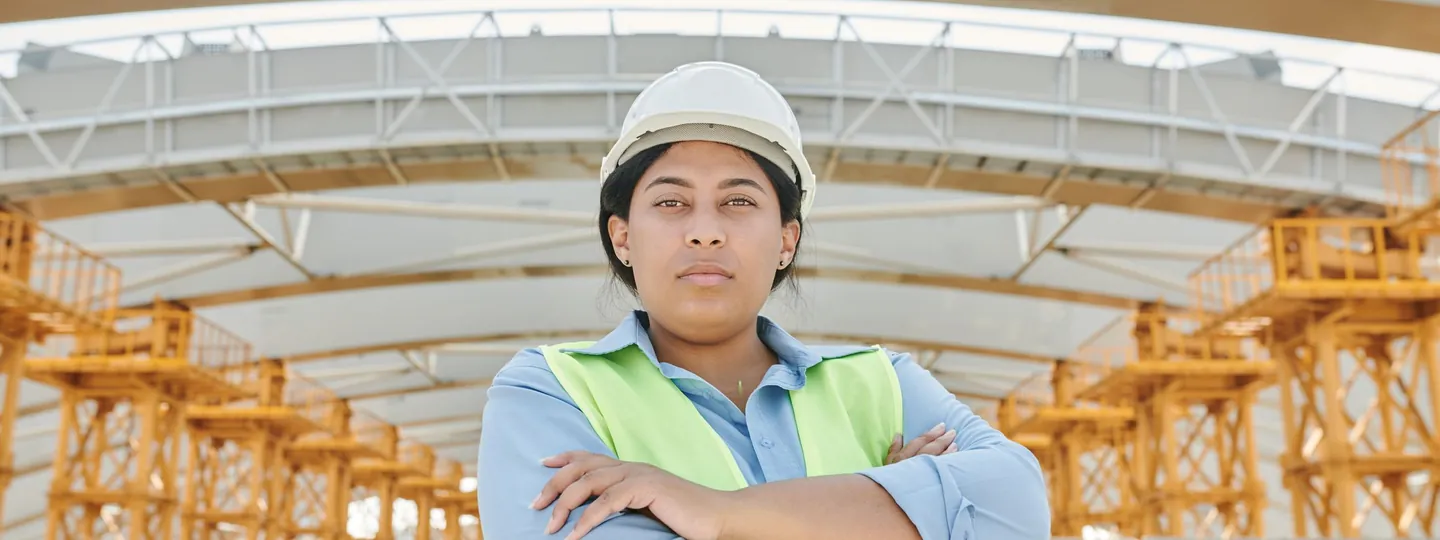 Ingeniera con casco y chaleco de seguridad en una obra